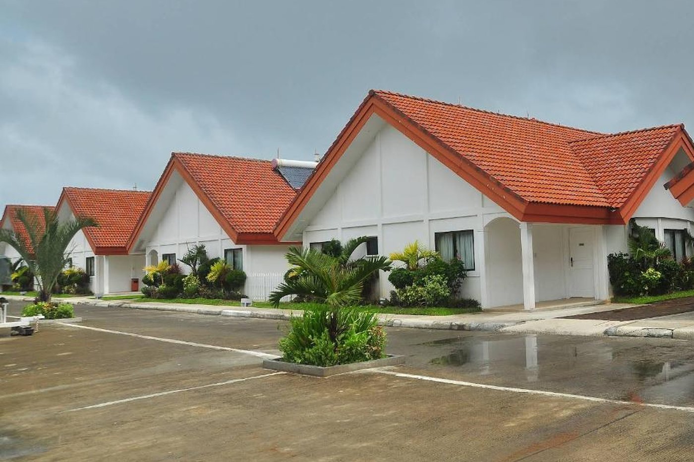Row of villas with red-tiled roofs after rain