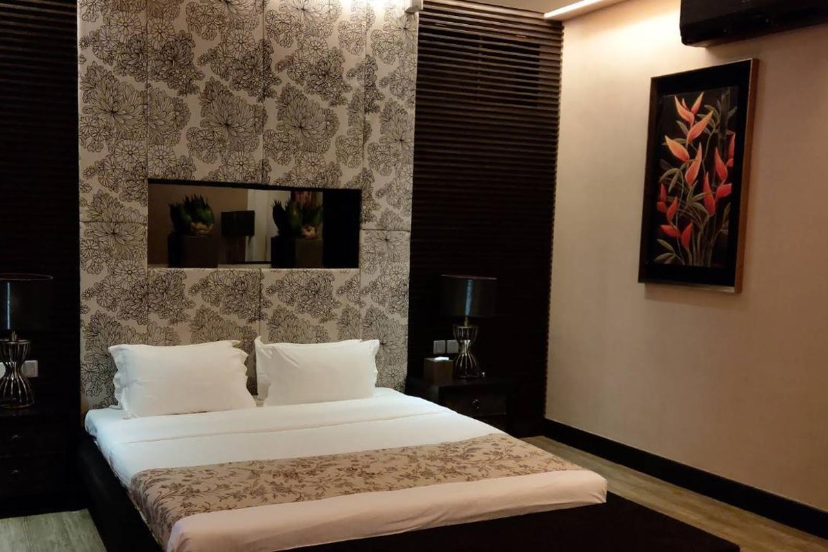 Master bedroom with white linens and floral headboard panel