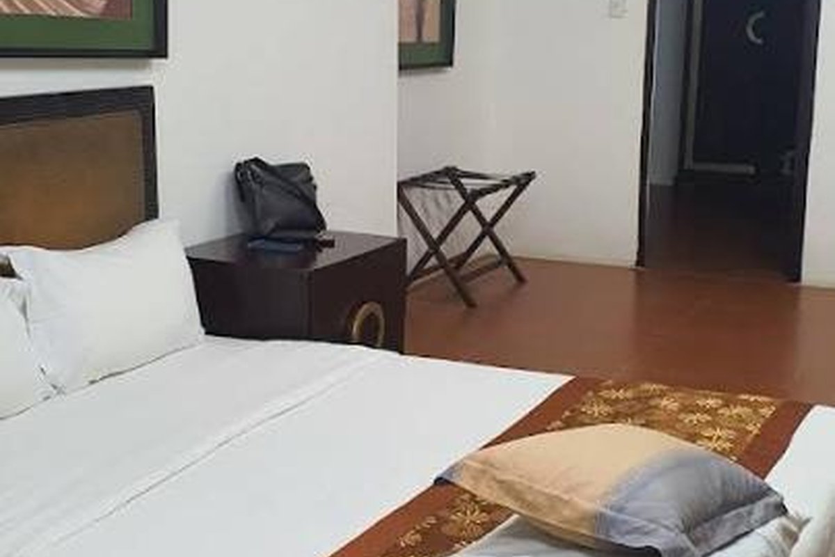 Bedroom with terracotta floor and white linens